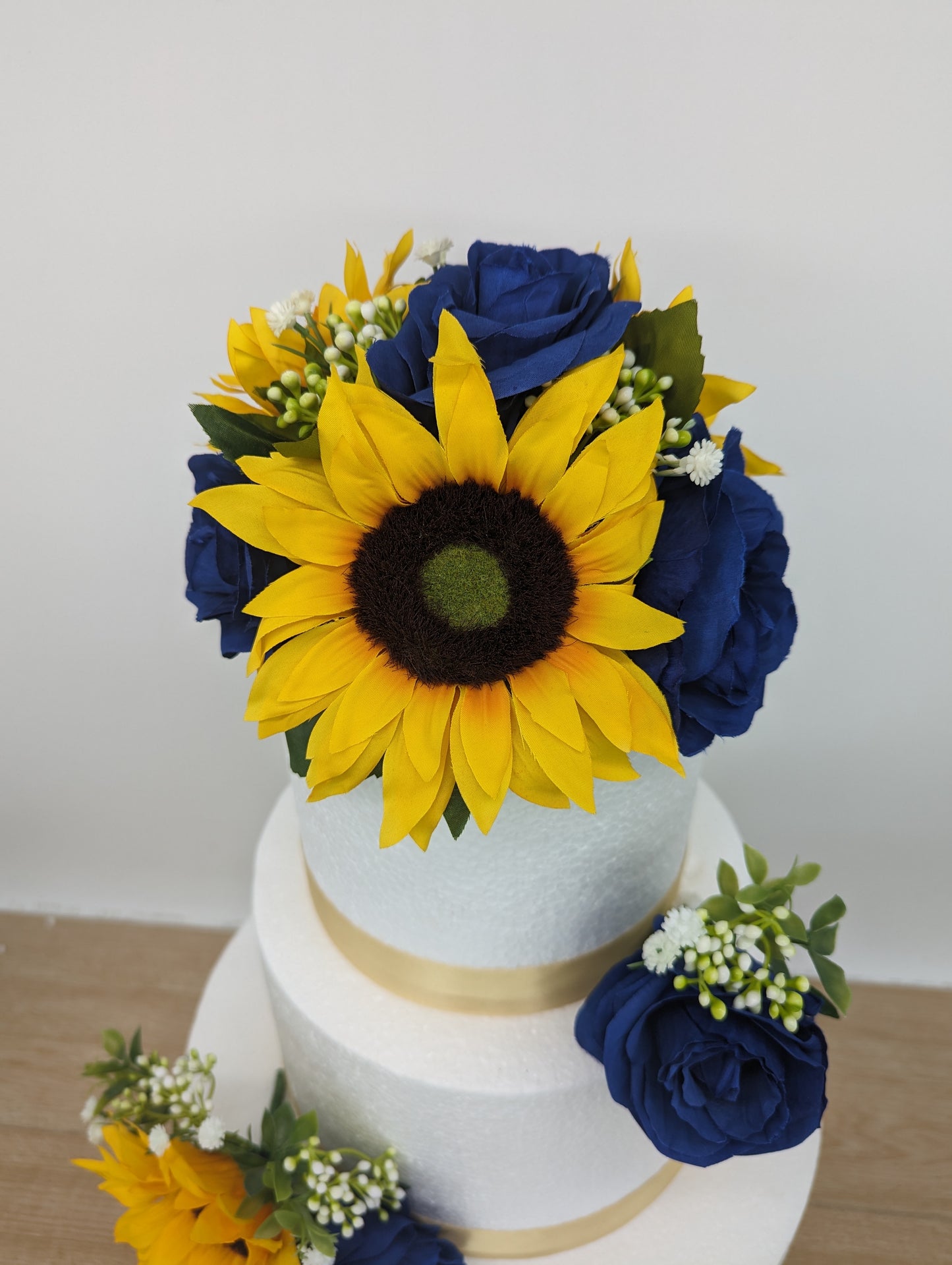 Sunflower, blue rose and foliage cake flowers and topper.