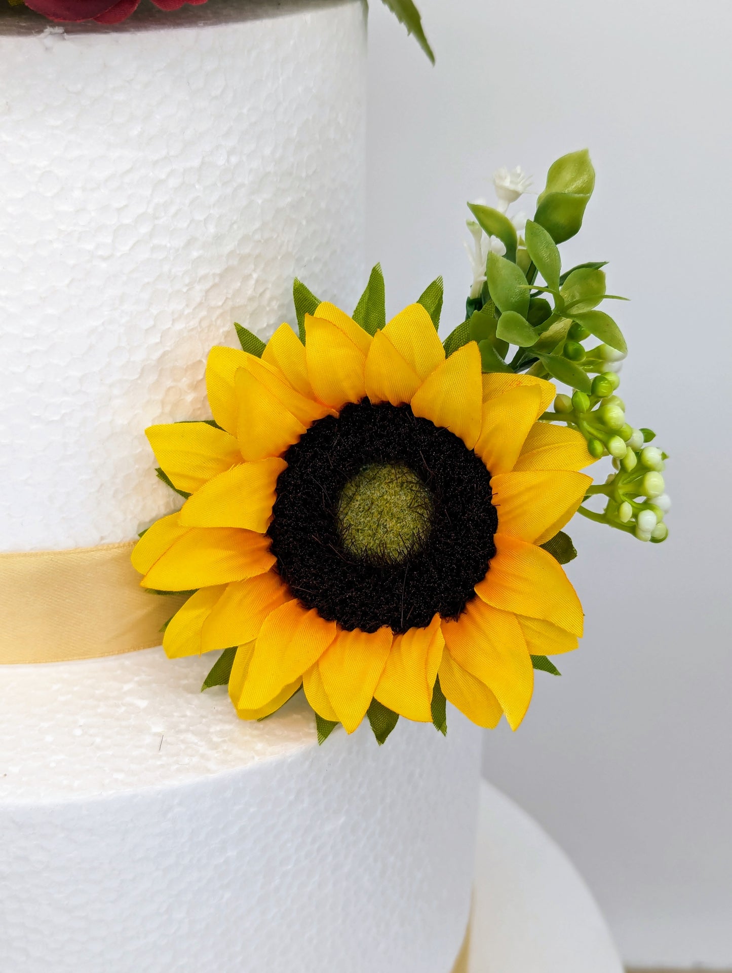 Sunflower, blue rose and foliage cake flowers and topper.