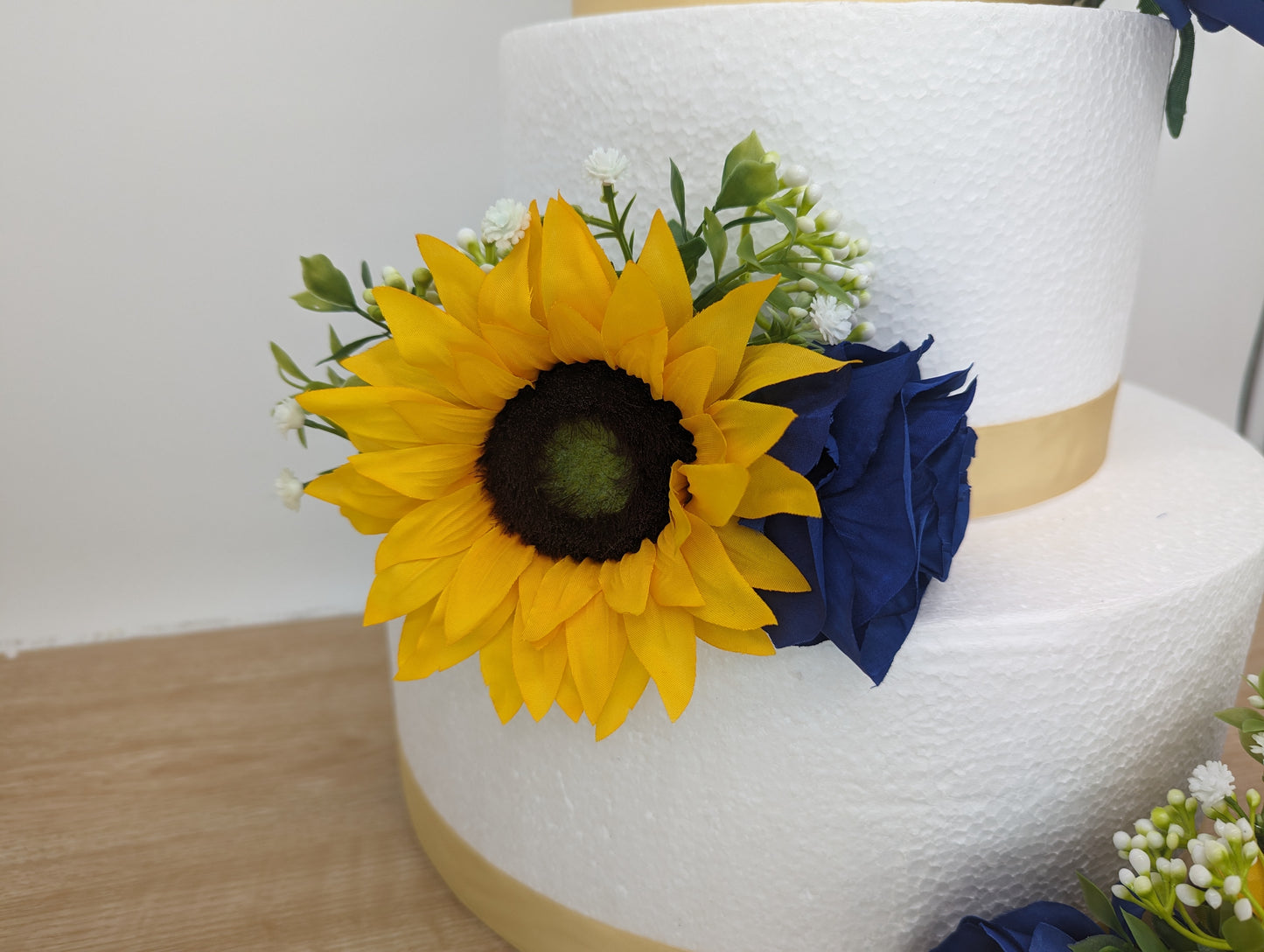 Sunflower, blue rose and foliage cake flowers and topper.